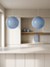 Kitchen island pendant light in a pair above a travertine island – blue swirl BO-HA Kaja globes.