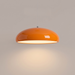 Orange pendant light casting a warm pool of light over a dining room table